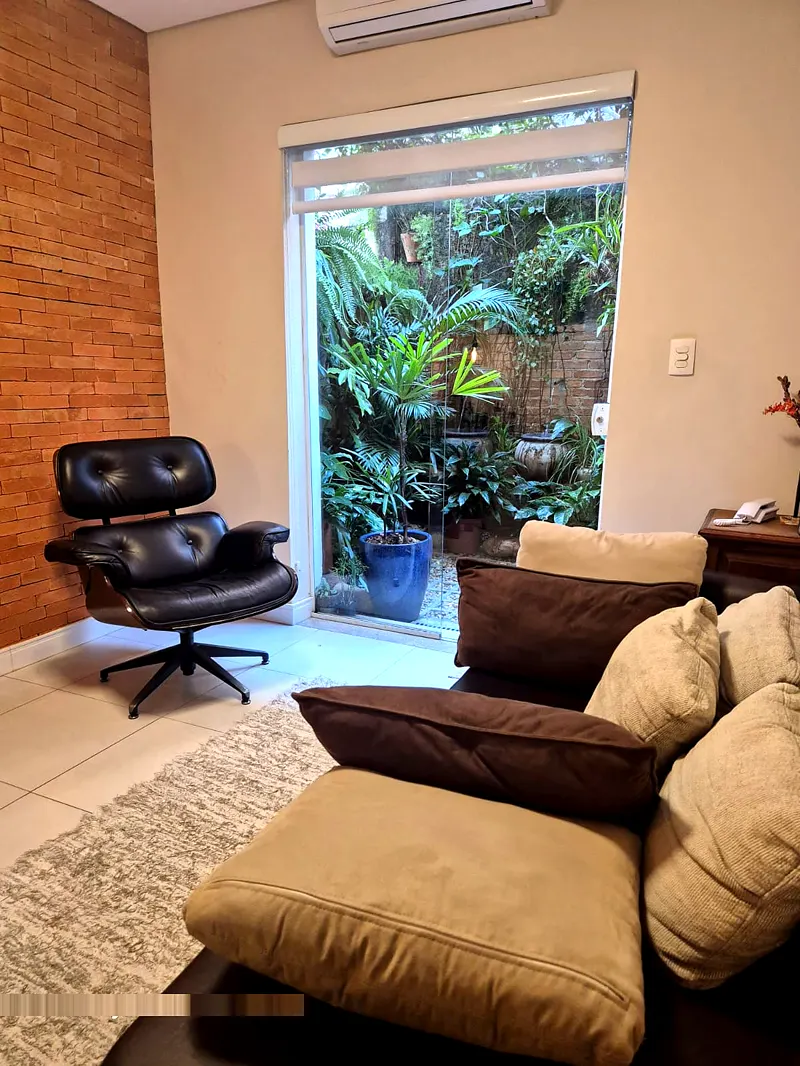 Sala de atendimento com poltrona e jardim ao fundo